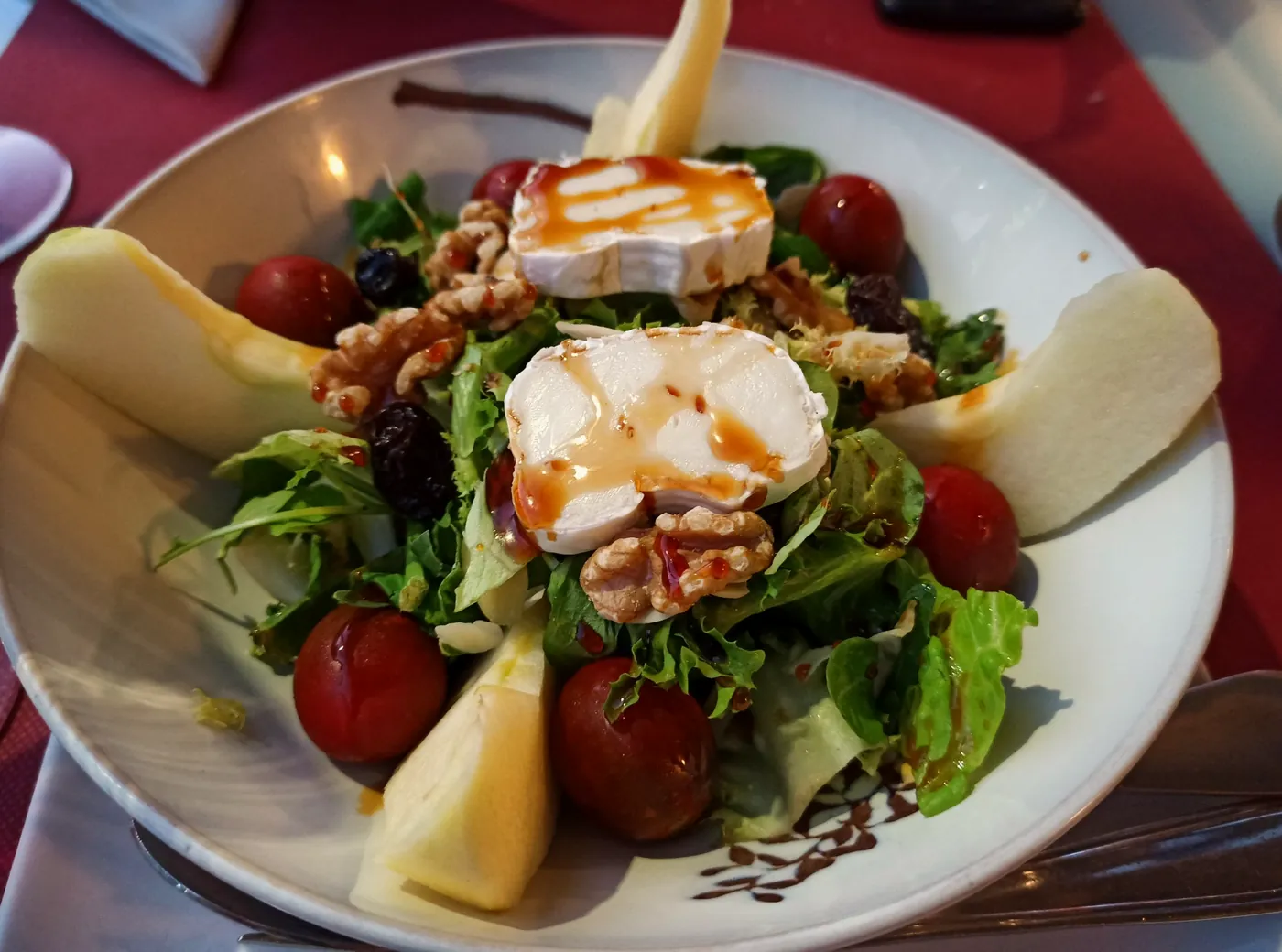 Ensalada de queso rulo de cabra con nueces, tomate cherry y fruta