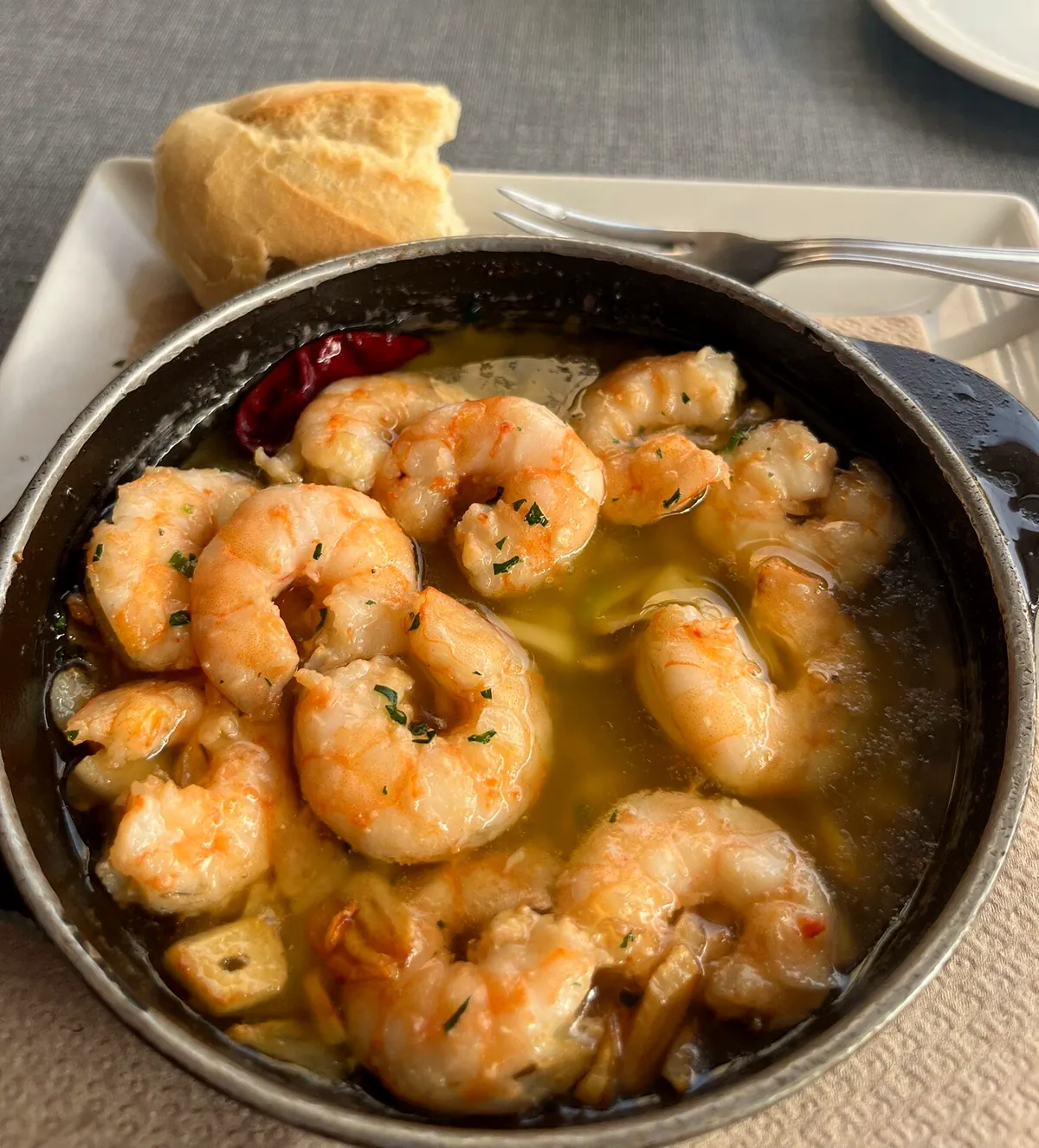 Gambas al ajillo en cazuela de hierro con guindilla y pan